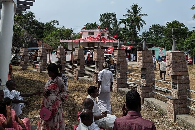 Villagers seated among the pillars of the Keezhvenmani memorial during a commemoration