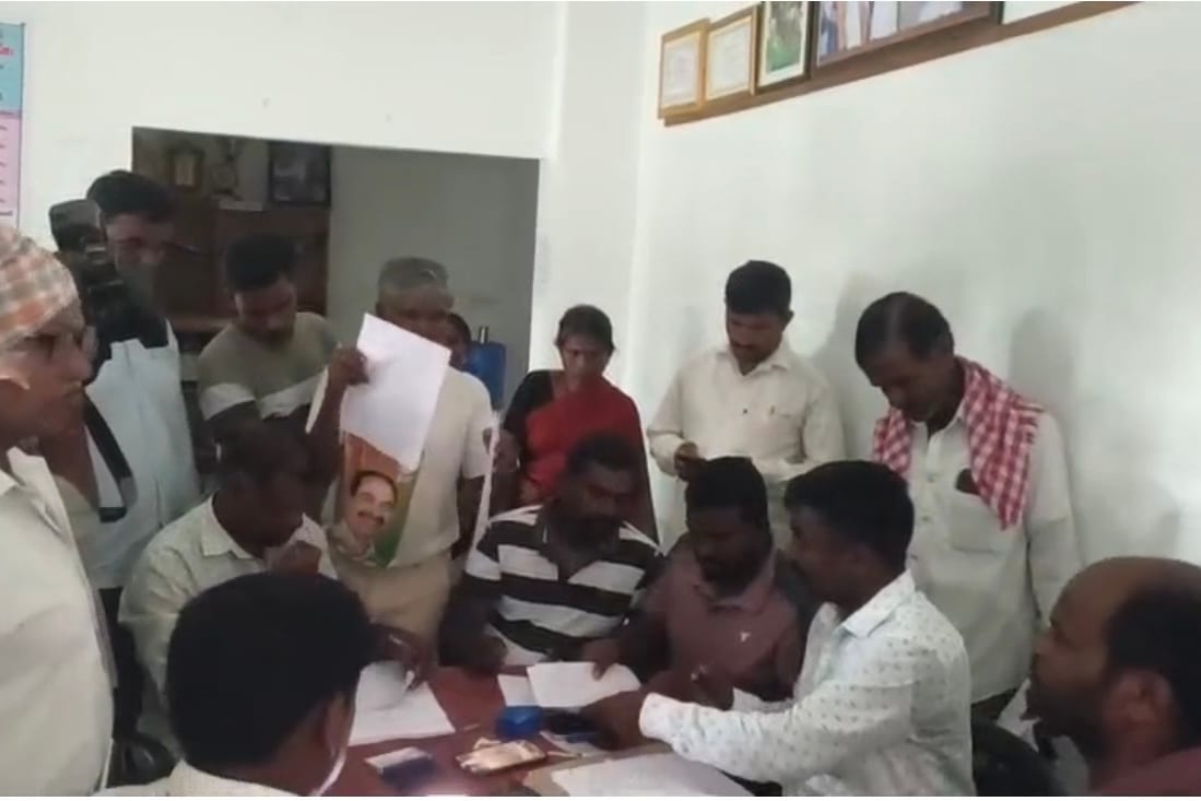Farmers hand papers to revenue officials seated at a table during the Erravalli land survey in Telangana
