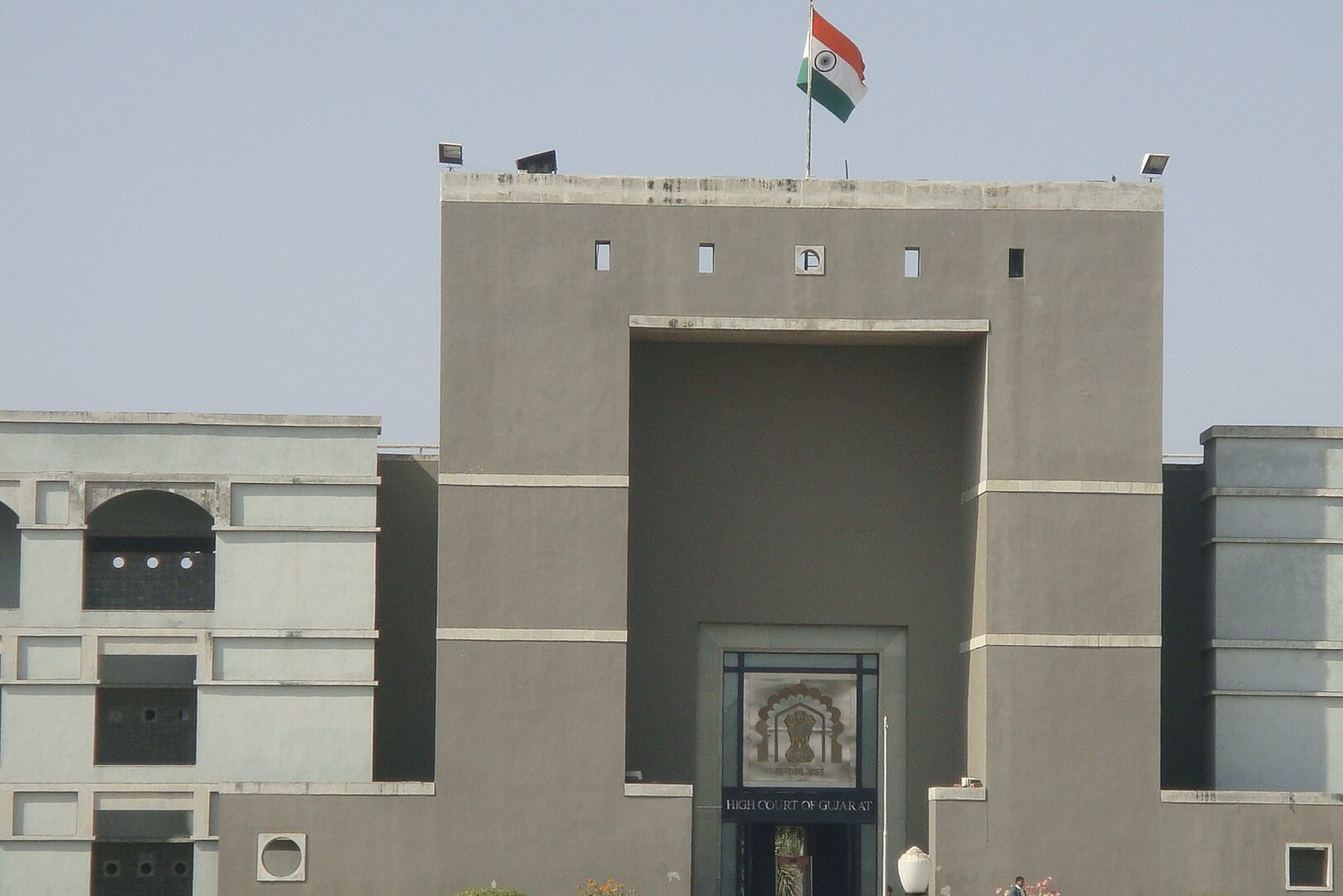 The entrance block of the Gujarat High Court building, with the court emblem and the sign High Court of Gujarat above the doorway
