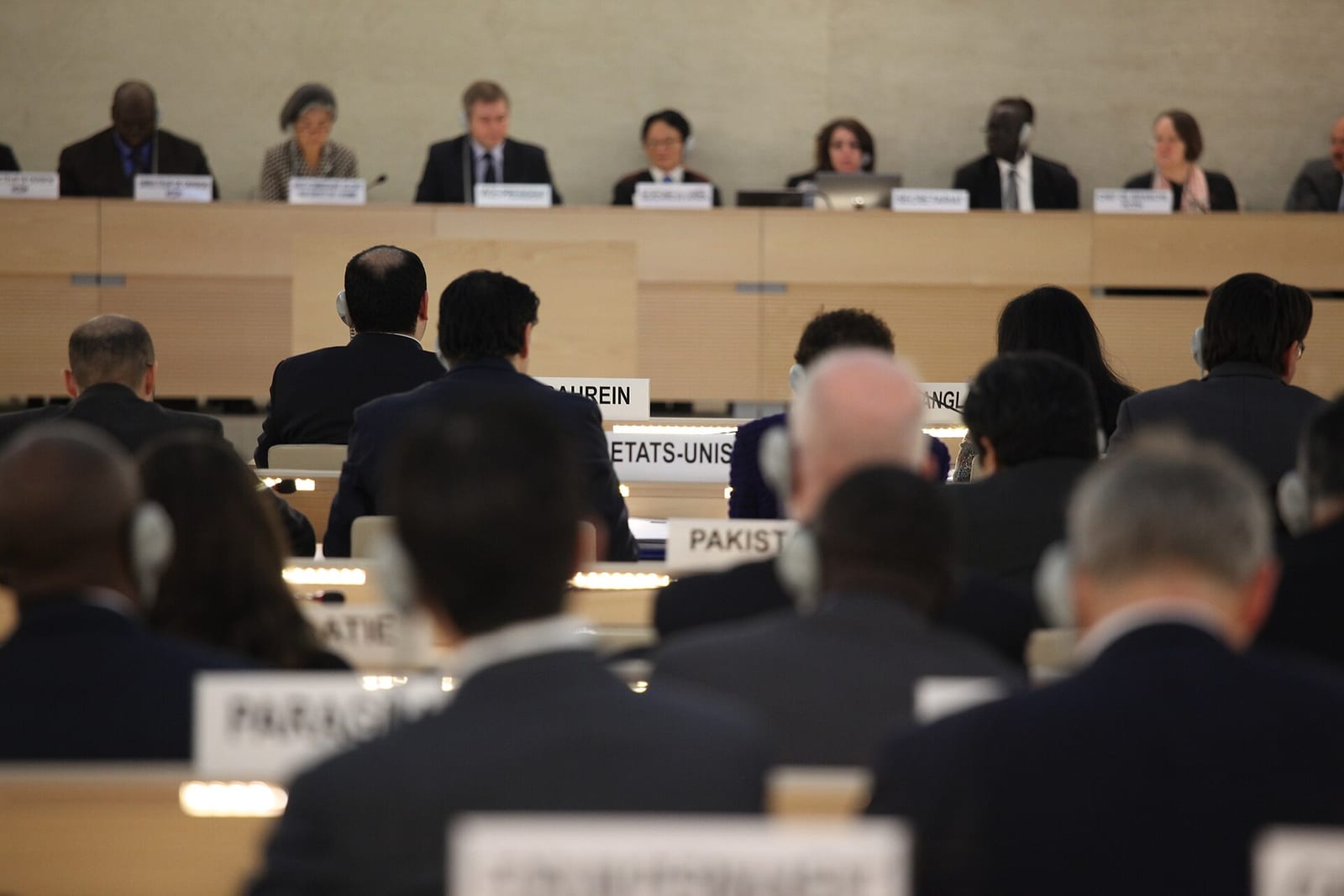 Delegates seen from behind at their desks in the UN Human Rights Council chamber in Geneva, facing the presiding panel